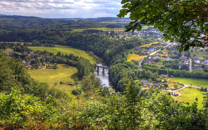 Aerial view of a village nestled in a valley with a river