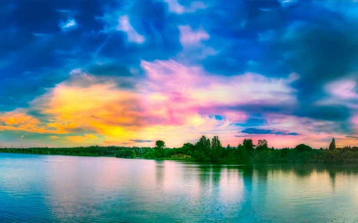 Colorful sunset clouds over a lake and trees