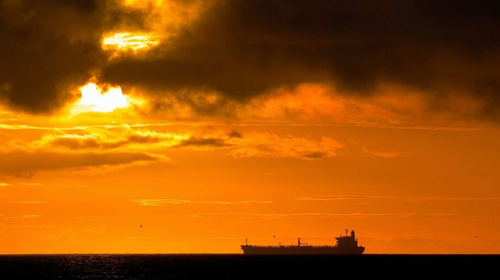 Ship sailing on the ocean during sunset