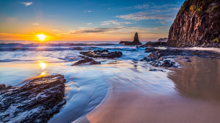 Sunset over a rocky beach with ocean waves