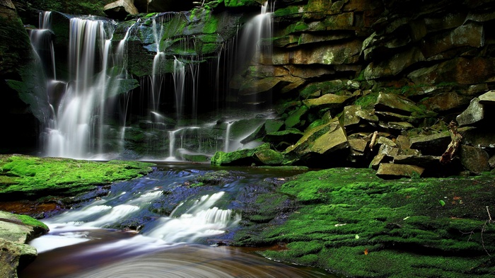 Waterfall cascading over moss-covered rocks into a stream
