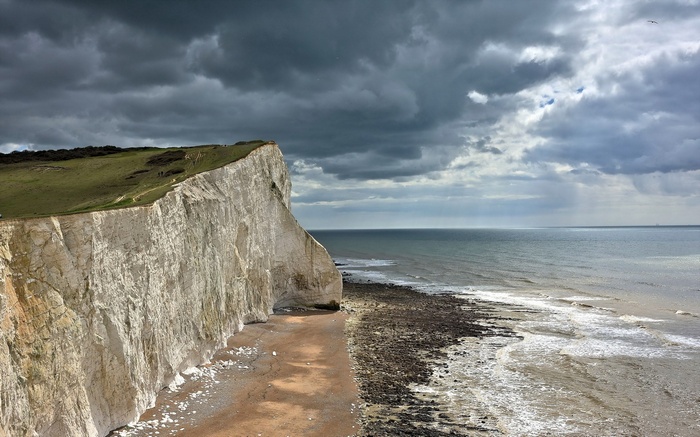 White cliffs overlooking the sea under a cloudy sky