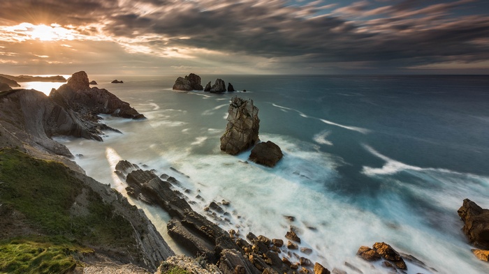 Rocky coastline with waves at sunset