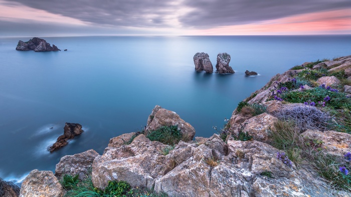 Coastal rock formations in the ocean at sunset