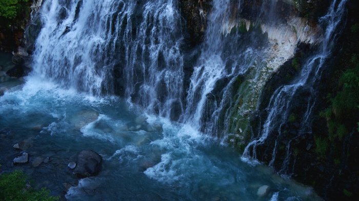 Waterfall cascading into a blue river