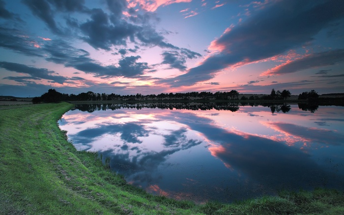 Sunset over a calm lake with reflections
