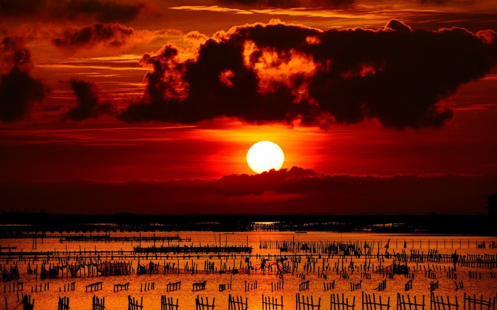 Sunset over a body of water with wooden structures