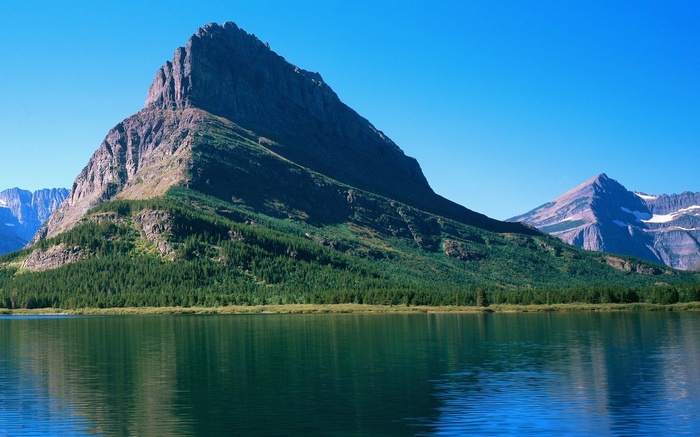 Mountain reflected in a lake under a clear blue sky