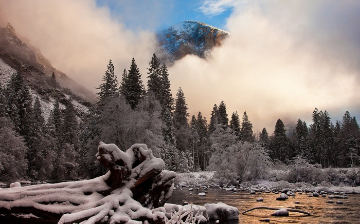 Snowy Yosemite Valley with El Capitan peeking through clouds