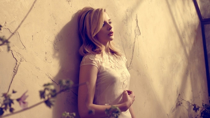 Scarlett Johansson leaning against a textured wall
