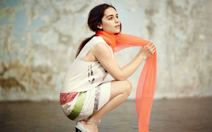 Emilia Clarke posing with an orange scarf