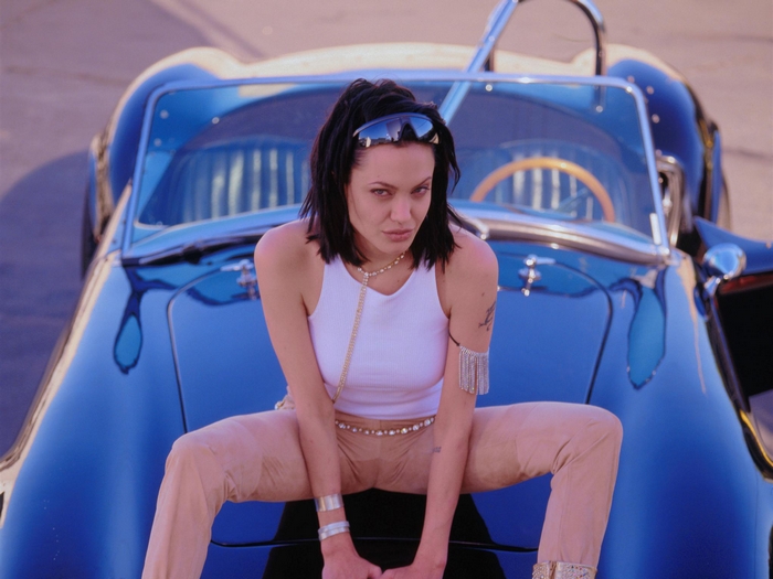Angelina Jolie sitting on a blue car