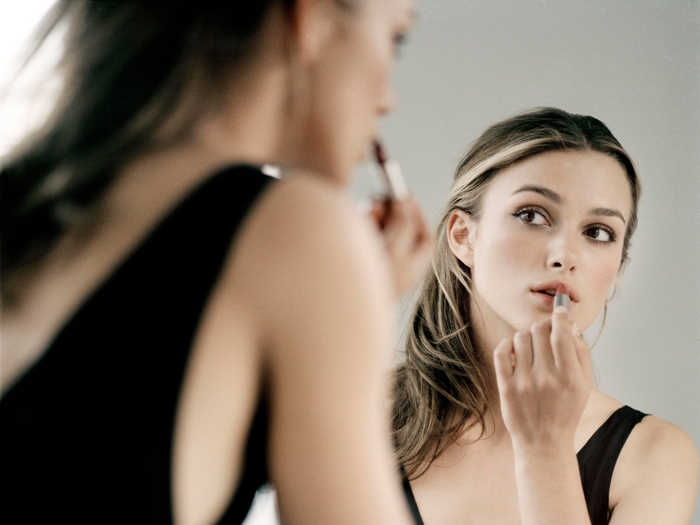 Keira Knightley applying lipstick in mirror