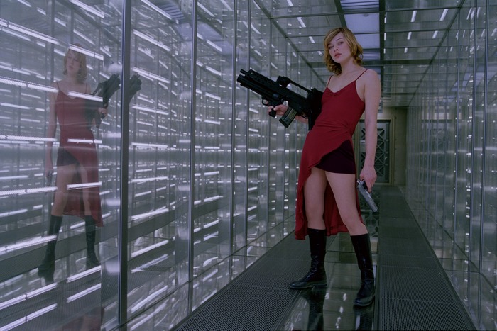 Milla Jovovich in a red dress holding guns