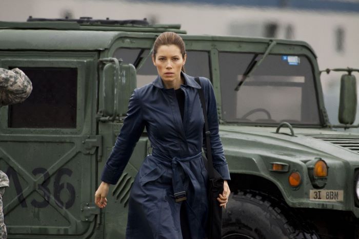 Jessica Biel in front of a military vehicle