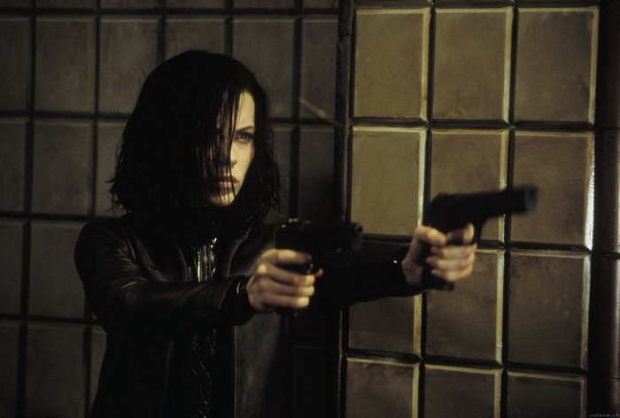 Kate Beckinsale holding two pistols