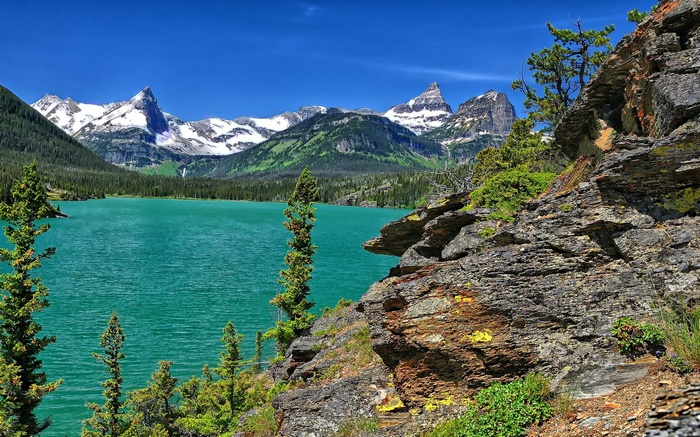 Turquoise lake and snow-capped mountains under blue sky