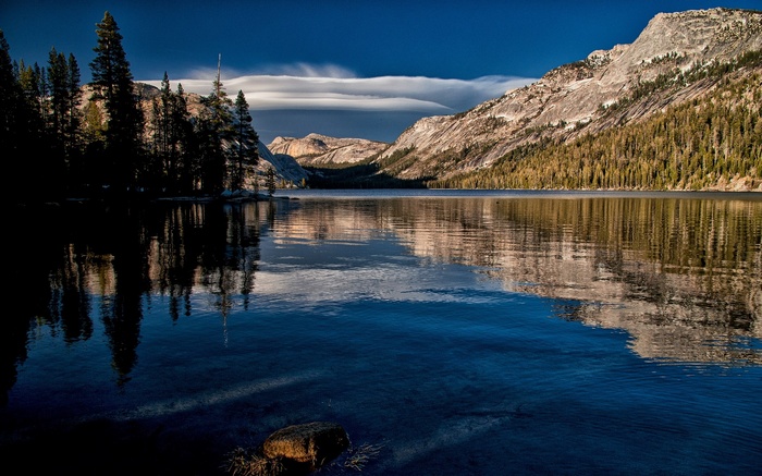 Lake with mountains and trees reflected in water