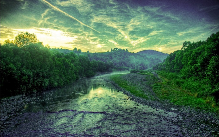 River flowing through a forest valley at sunrise
