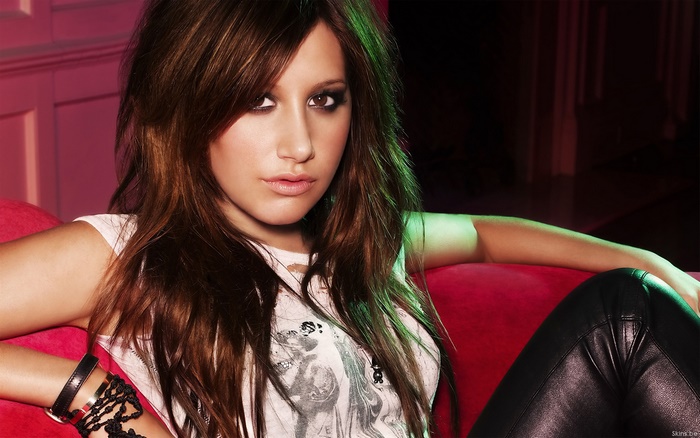 Ashley Tisdale on a red couch