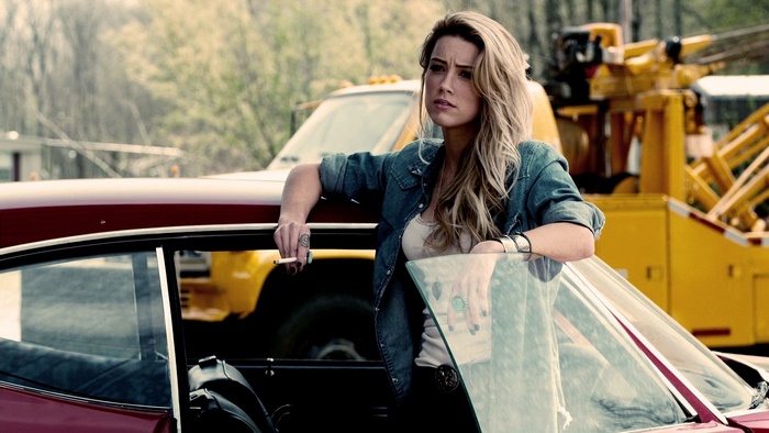Amber Heard leaning on a car with a cigarette