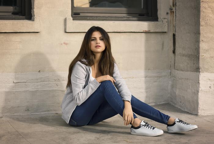 Selena Gomez sitting on the ground