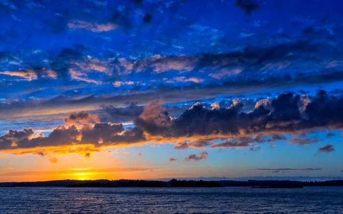 Sunset over water with dramatic clouds