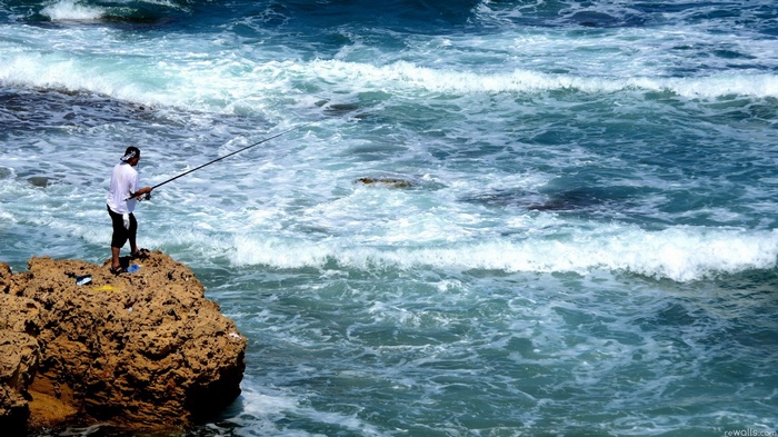 Man fishing from a rock in the ocean