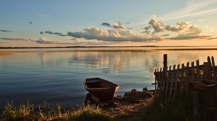 Boat on a lake at sunset with clouds