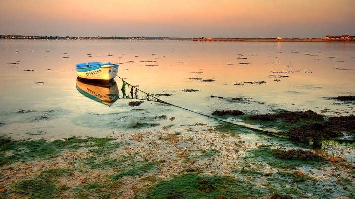 Two boats moored in calm water at sunset