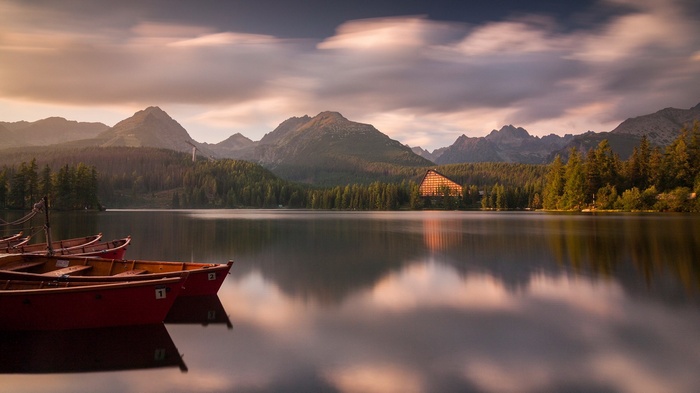 Boats on a lake with mountains and a hotel