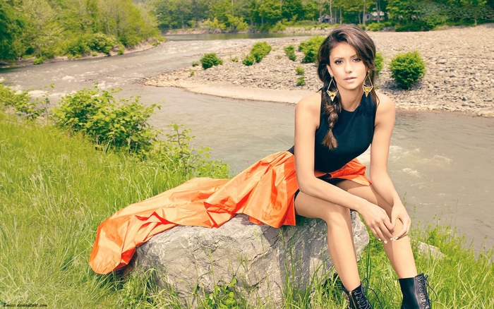 Nina Dobrev sitting by a river