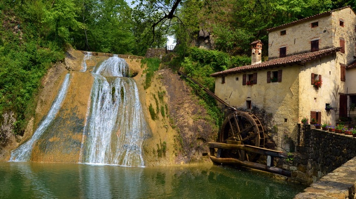 Waterfall and old mill building in a forest