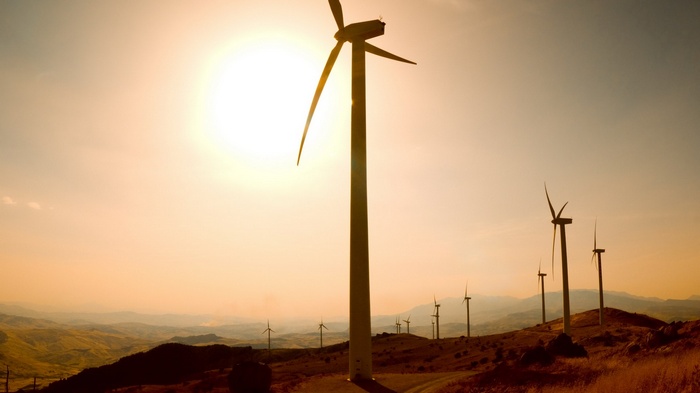Wind turbines on a hill at sunset