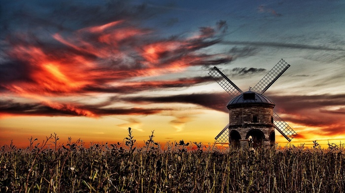 Windmill in a field at sunset