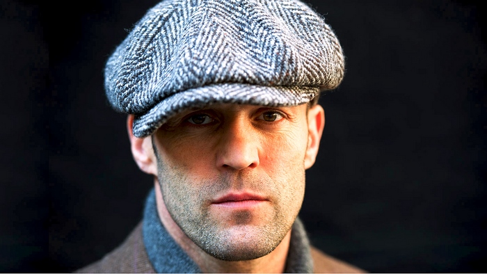 Jason Statham wearing a flat cap