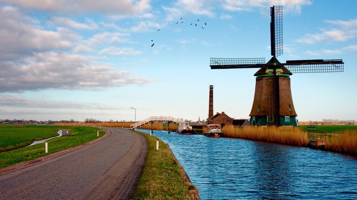 Windmill and canal with boats and bridge