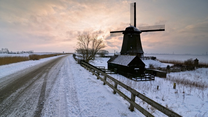 Snowy landscape with a windmill and a road