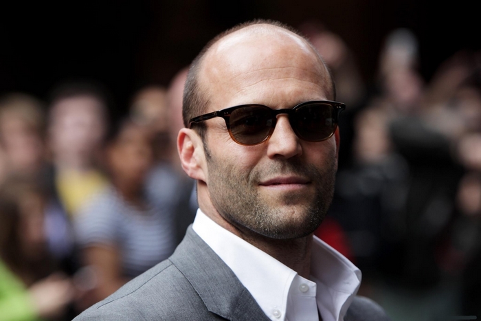 Jason Statham wearing sunglasses and a suit