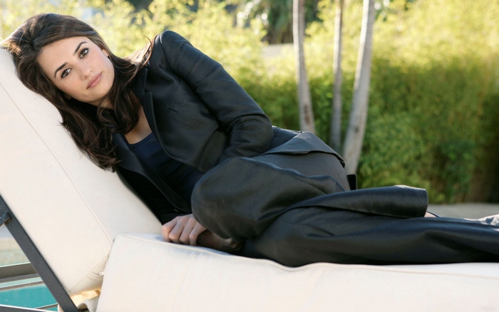 Penélope Cruz lounging on a chaise lounge outdoors