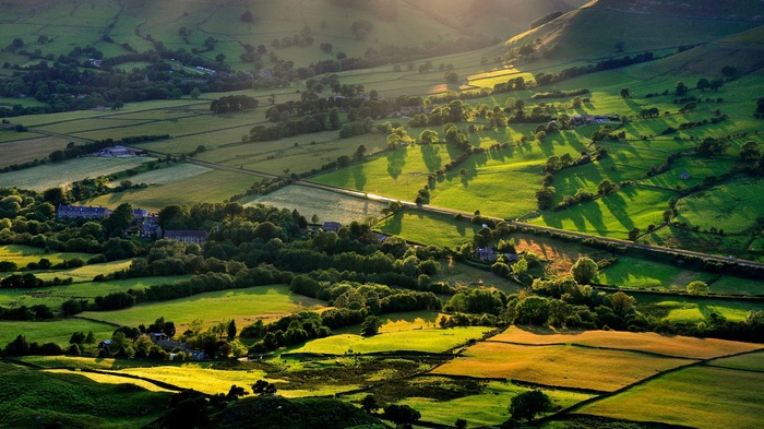 Rolling green hills with scattered trees and buildings