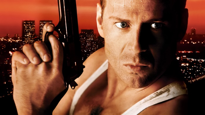 Bruce Willis holding a gun in front of a city skyline
