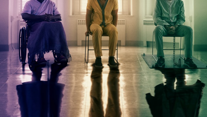 Bruce Willis in a wheelchair and two men in chairs