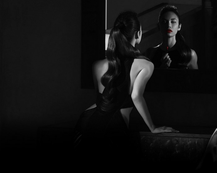 Olga Kurylenko applying red lipstick in a mirror
