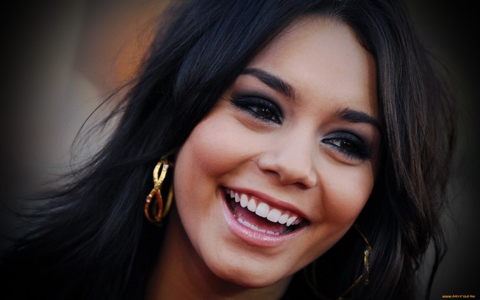 Vanessa Hudgens smiling with gold earrings