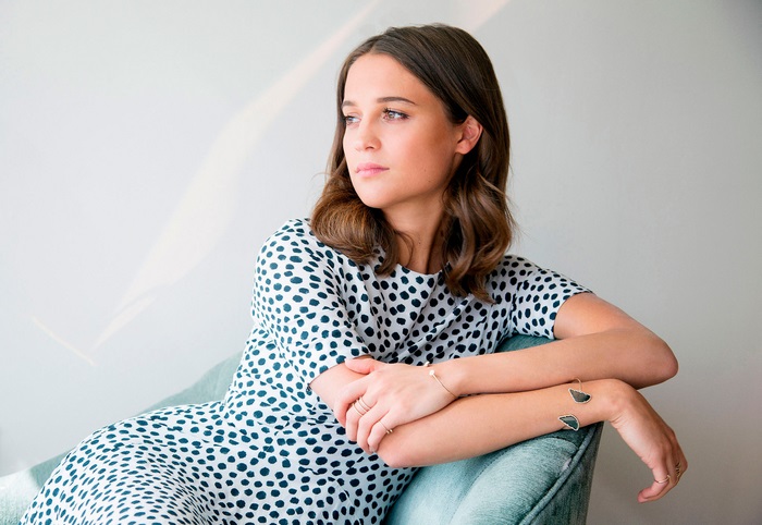 Alicia Vikander sitting on a chair