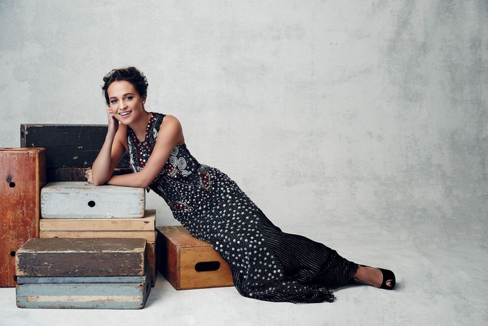 Alicia Vikander posing on wooden crates