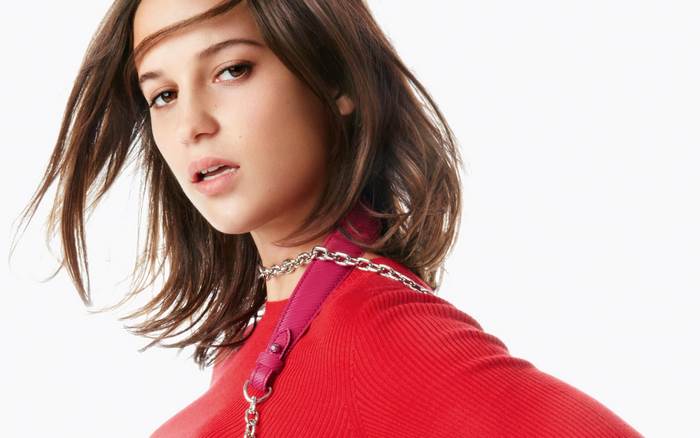 Alicia Vikander in red sweater with chain necklace