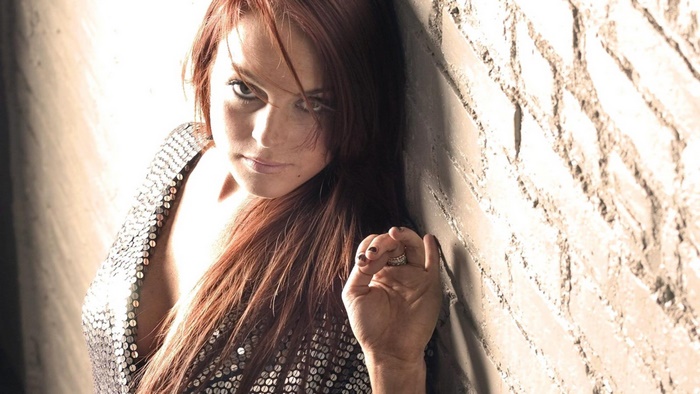 Lindsay Lohan leaning against a brick wall