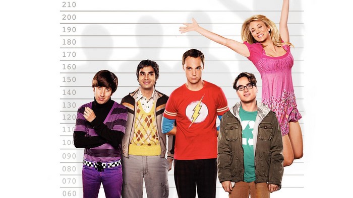 The Big Bang Theory cast posing against a height chart